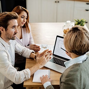 A couple is sitting at a table with an attorney, Represented Estate planning.